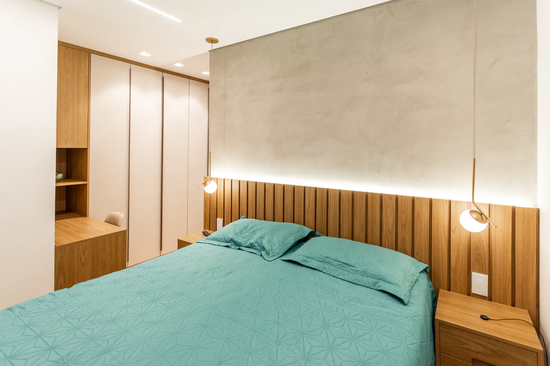 Quarto planejado de casal com cabeceira ripada iluminada e marcenaria clara, projeto Linear em São Paulo