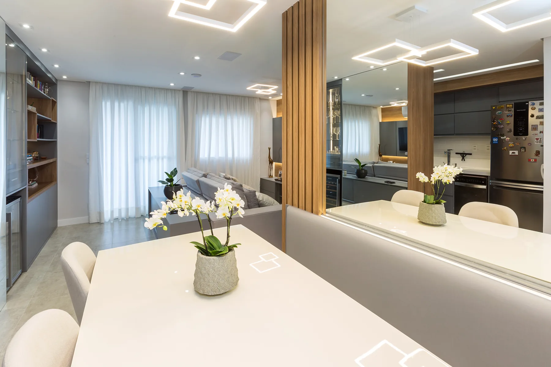 Sala de jantar planejada com mesa, espelho e painel ripado ampliando o ambiente, projeto Linear na zona sul de São Paulo